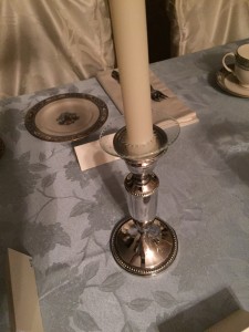Glass bobeshe resting on top of a candlestick.