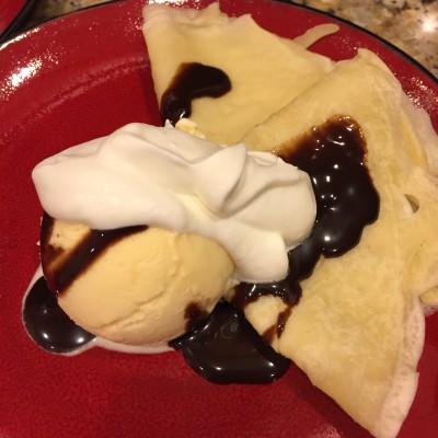 Crepes with ice cream, whipped cream and chocolate sauce.