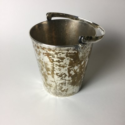 The gold color showing on this ice bucket is the base metal, most likely brass.