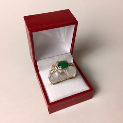 A vintage cocktail ring features carved quartz and an emerald.