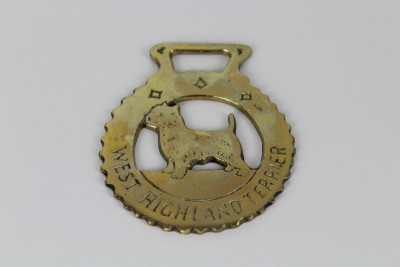 A West Highland Terrier (or Westie) is on this brass harness.